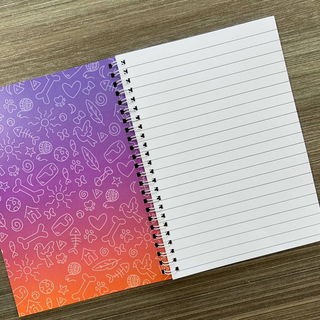 Notebook with colorful cover and lined pages on a wooden surface