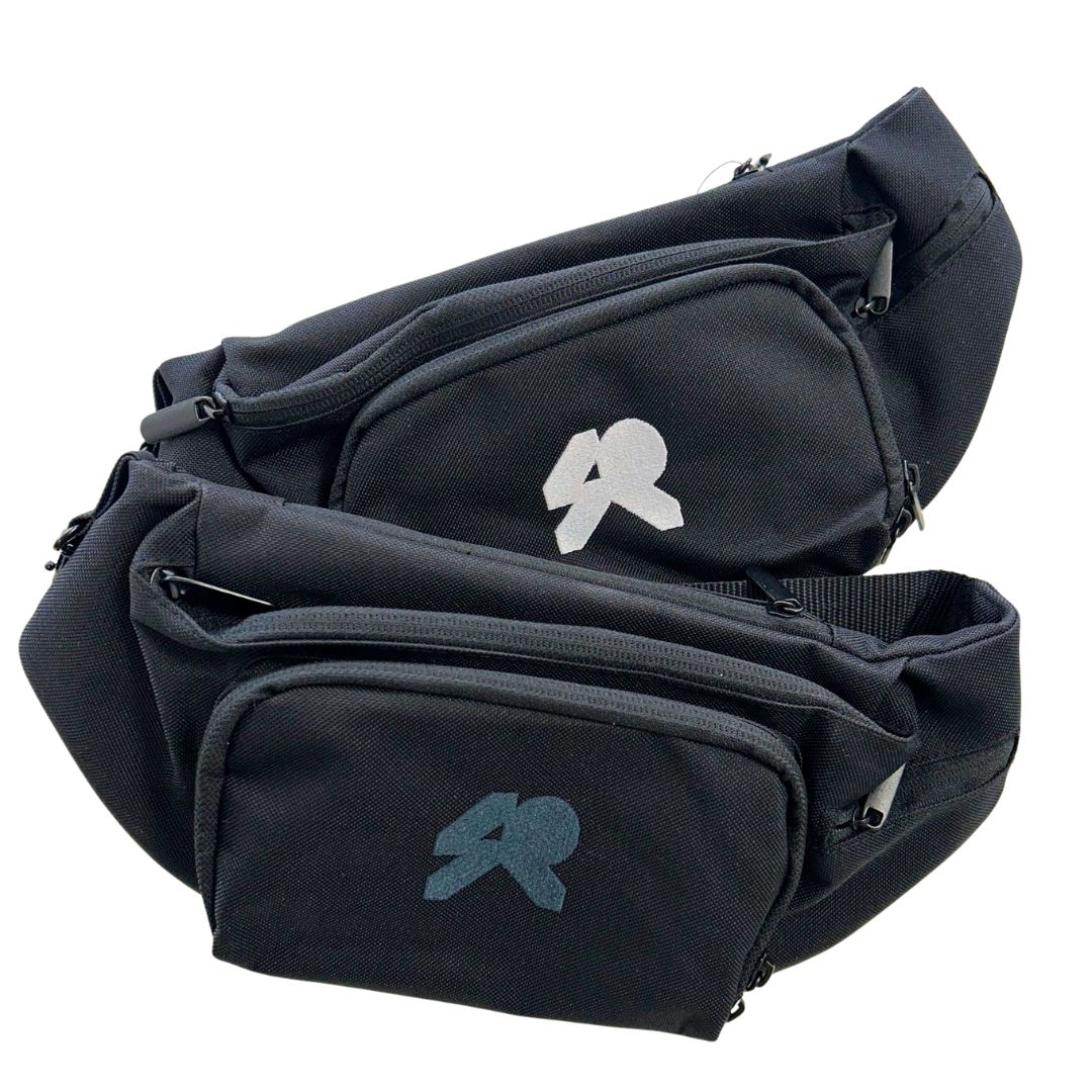Black canvas waistbags with adjustable straps one with a white logo, the other with a black logo.